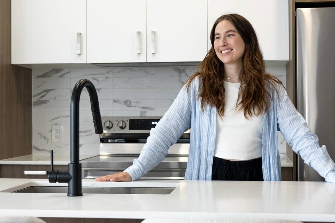 Jeune femme heureuse d’avoir loué un condo au sein du projet Signature Bois-Franc, à Saint-Laurent, Montréal